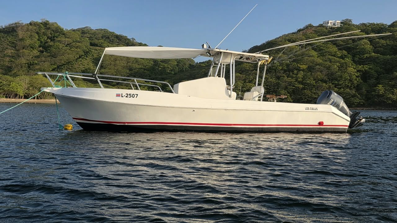 Los Cielos — AquaSport 32-foot center console charter boat with outriggers and Yamaha outboard anchored in Playa El Jobo